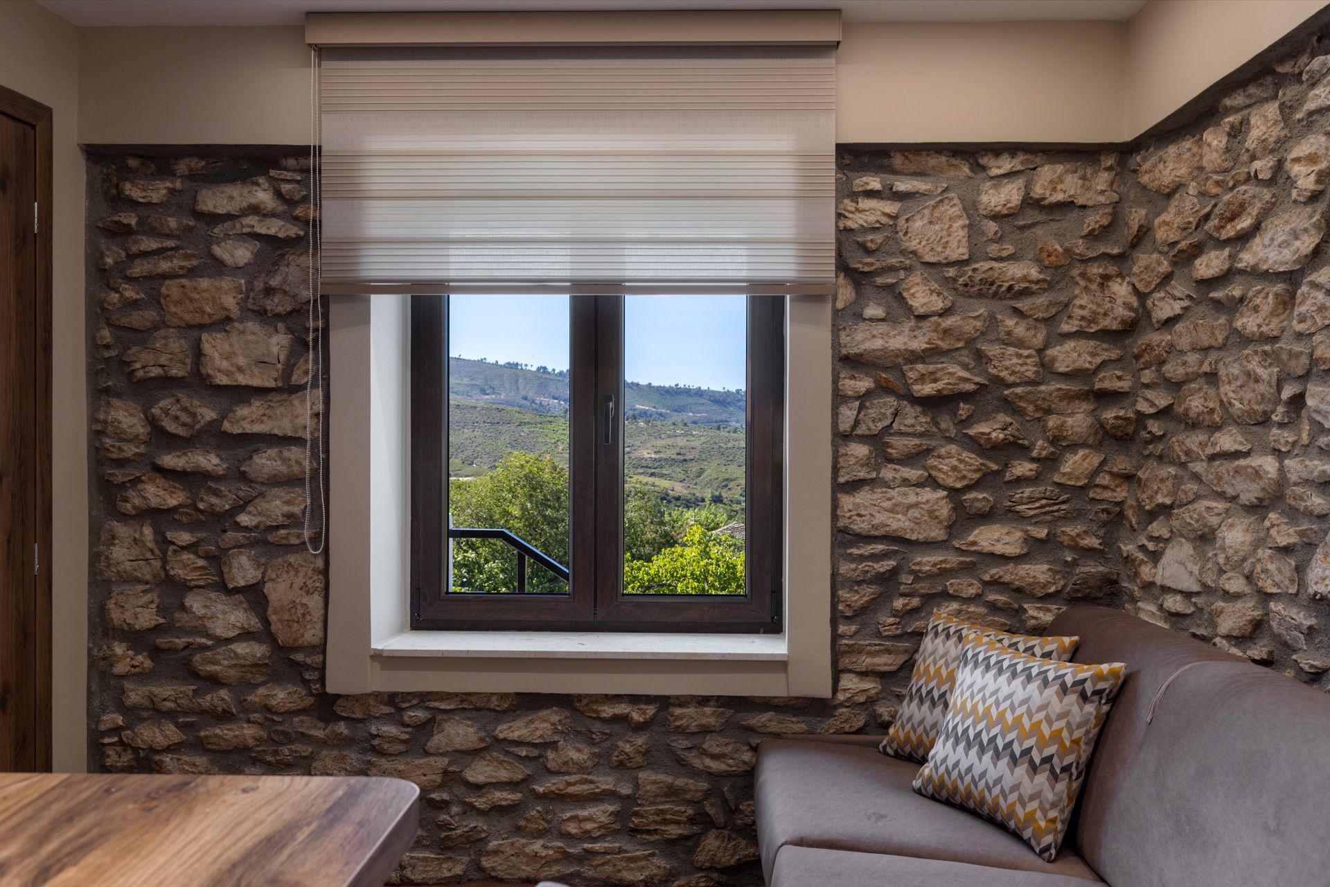 Anemoessa's living room, with bare stone walls and a window onto the hills