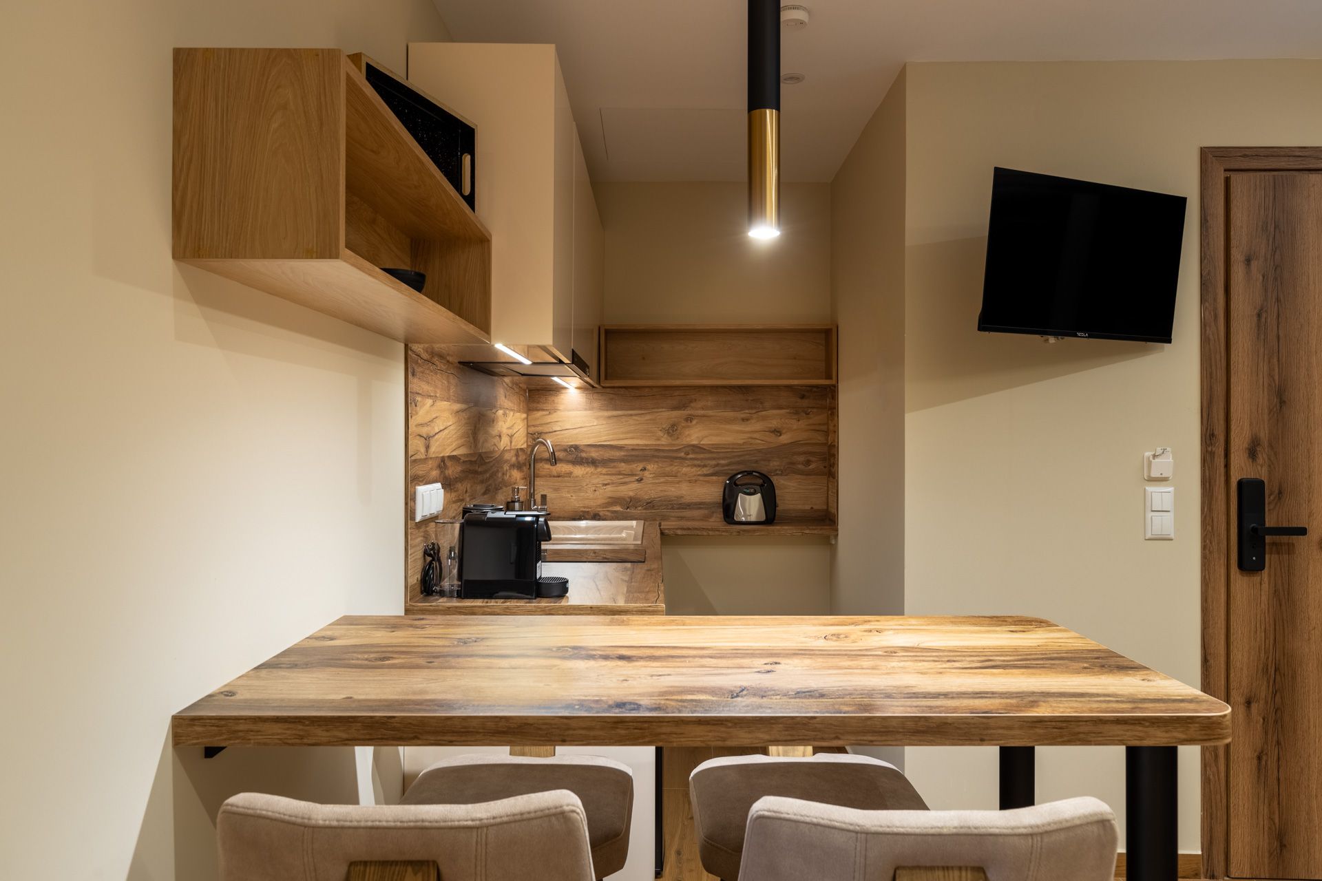 Anemoessa's table and Smart TV, with the kitchen behind