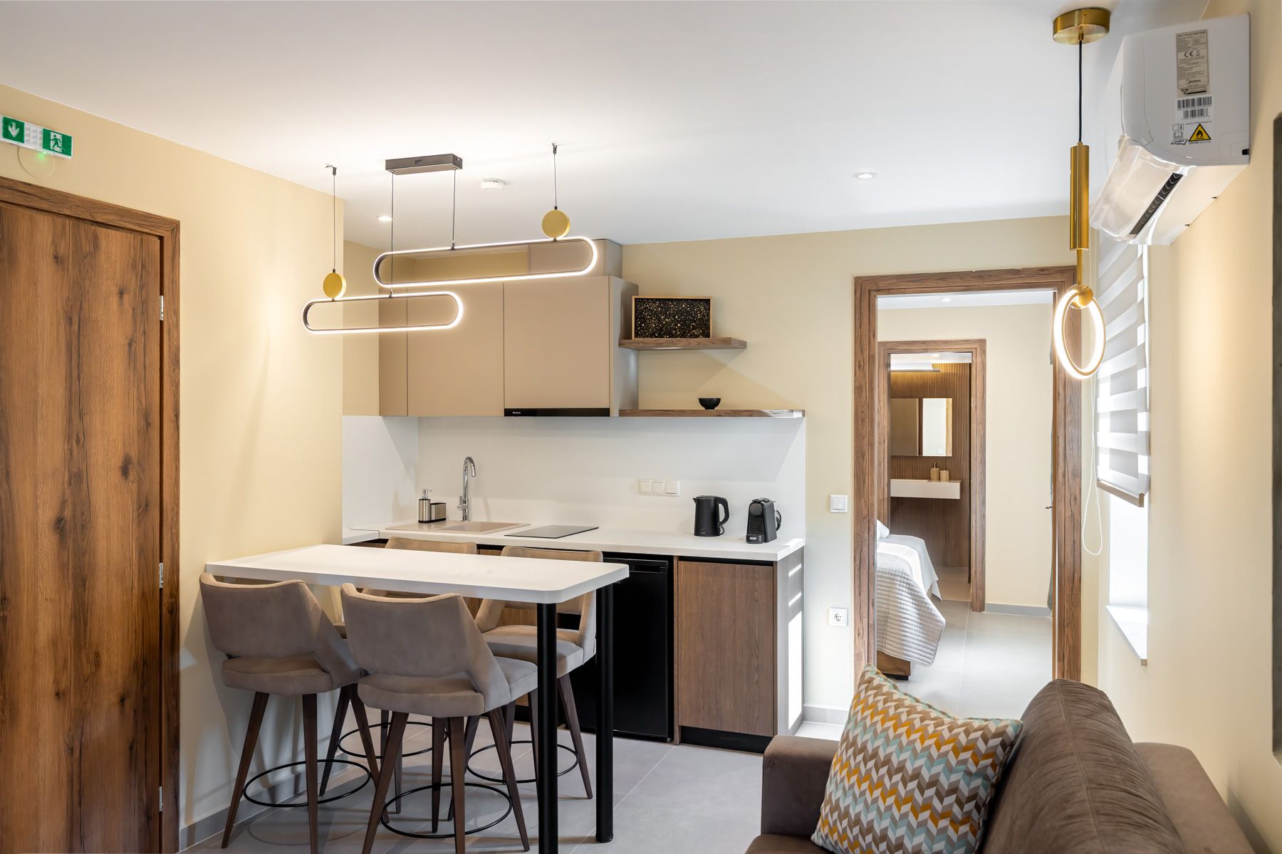 The open living room and kitchen of Asteroessa, with brass ring pendants over the breakfast bar