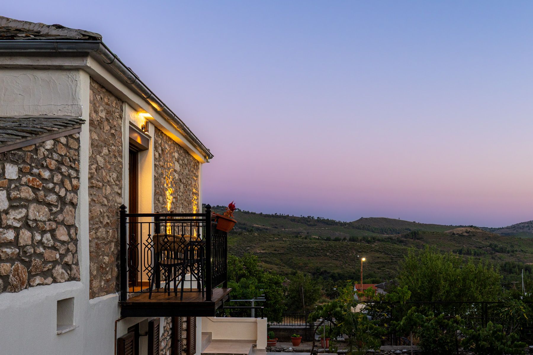 The iron balcony at dusk, with the ridge beyond